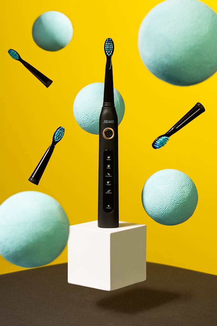 Services-01 Dynamic studio shot of an electric toothbrush with colorful floating elements.